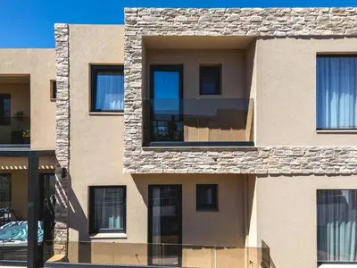 a facade of a building with black windows at Aigialí Essence in Vrachonisída touArchangélou