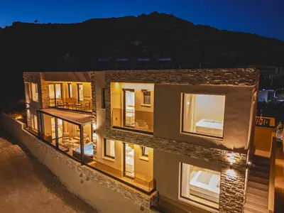 a building with many windows at night at Aigialí Essence in Vrachonisída touArchangélou