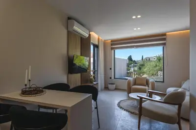 a living room with a couch and a table and chairs at Aigialí Essence in Vrachonisída touArchangélou