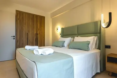 a bedroom with two towels on a large bed at Aigialí Essence in Vrachonisída touArchangélou