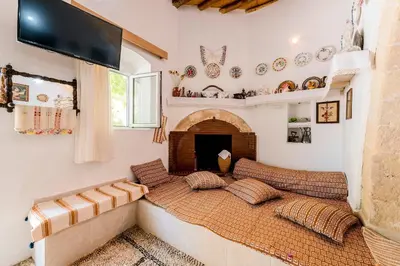a living room with a bed with a fireplace at Kamariko Traditional House in Afantou