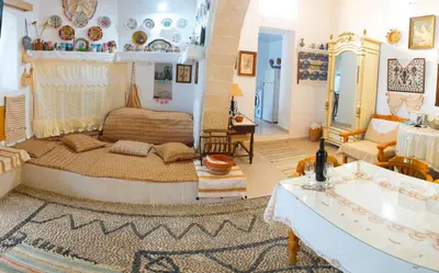a bedroom with a large bed and a living room at Kamariko Traditional House in Afantou