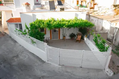 a white house with a white fence and a patio at Kamariko Traditional House in Afantou