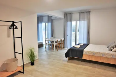a bedroom with a bed and a table and chairs at Telhinis Hotel & Apartments in Faliraki