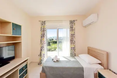 a bedroom with a bed and a tv and a window at Seraina House in Pastida