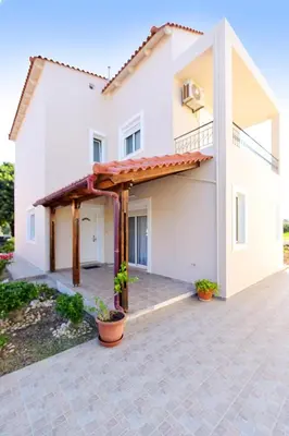 a large white house with a patio at Seraina House in Pastida