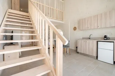 a wooden staircase in a kitchen next to a counter at Kathara bay Studios in Faliraki