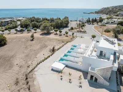 an aerial view of a white house with a beach at Kathara bay Studios in Faliraki