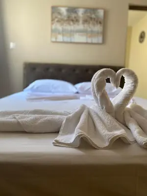 two towels shaped like swans sitting on a bed at Liora in Rhodes Town