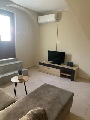 a living room with a couch and a flat screen tv at Liora in Rhodes Town