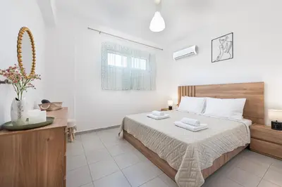 a bedroom with a bed with two towels on it at Panormitis House Semi-basement apartment in Pastida