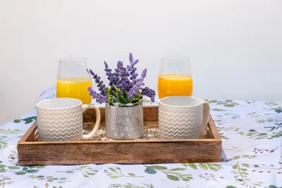 a tray with two cups and two glasses of orange juice at Panormitis House Semi-basement apartment in Pastida