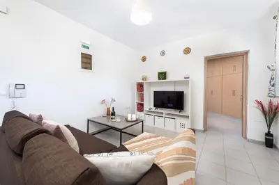 a living room with a couch and a tv at Panormitis House Semi-basement apartment in Pastida