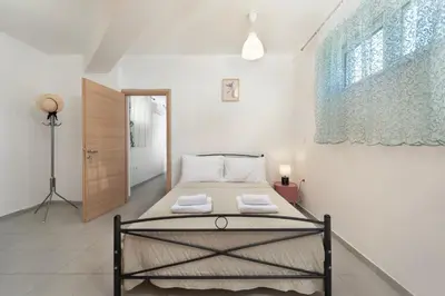 a bedroom with a bed with two towels on it at Panormitis House Semi-basement apartment in Pastida