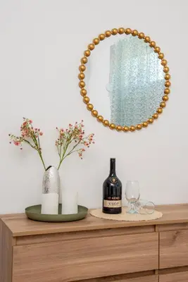 a mirror on top of a dresser with a bottle of wine at Panormitis House Semi-basement apartment in Pastida