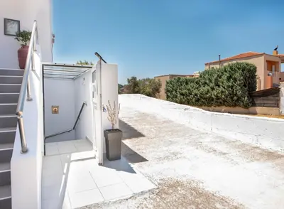 a door on the side of a house with stairs at Panormitis House Semi-basement apartment in Pastida