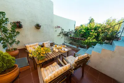a patio with a table and chairs on a balcony at Finestra Medieval Home in Rhodes Town