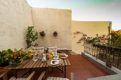 a table and chairs on a balcony with flowers at Finestra Medieval Home in Rhodes Town