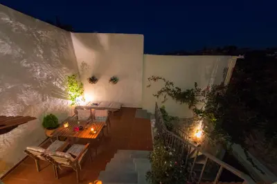 an outdoor patio with a table and chairs at night at Finestra Medieval Home in Rhodes Town