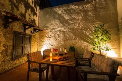 a wooden table with chairs and a candle on it at Finestra Medieval Home in Rhodes Town