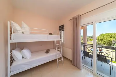 a bedroom with two bunk beds and a balcony at SunnyVilla Rhodes in Ialyssos
