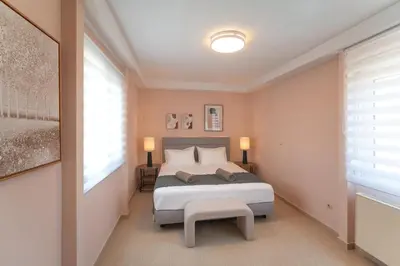 a bedroom with a bed and a bench in it at SunnyVilla Rhodes in Ialyssos
