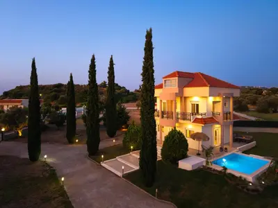 a villa with a swimming pool in front of a house at SunnyVilla Rhodes in Ialyssos