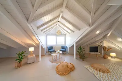 a living room with chairs and a tv and a couch at SunnyVilla Rhodes in Ialyssos