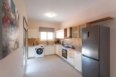 a kitchen with a stainless steel refrigerator and a dishwasher at SunnyVilla Rhodes in Ialyssos