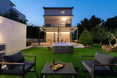 a backyard with a hot tub and a house at Diverso Inn in Koskinou