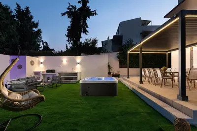 a backyard with a hot tub in the grass at Diverso Inn in Koskinou
