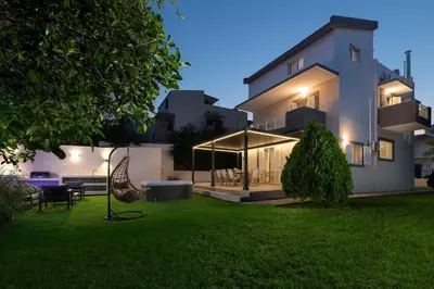a house with a lawn in front of it at Diverso Inn in Koskinou