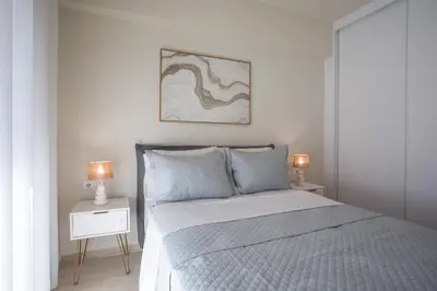 a bedroom with a bed and two lamps on a night stand at Vasi Luxury Apartment in Rhodes Town