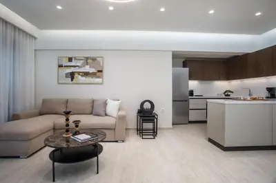 a living room with a couch and a table and a kitchen at Vasi Luxury Apartment in Rhodes Town