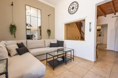 a living room with a couch and a clock on the wall at The Neo-Classic Loft in Rhodes Town