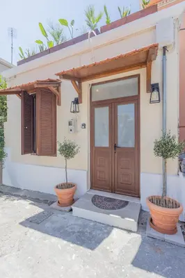 a house with two potted trees in front of a door at The Neo-Classic Loft in Rhodes Town