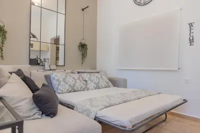 a couch with pillows on it in a living room at The Neo-Classic Loft in Rhodes Town
