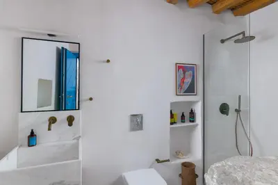 a white bathroom with a mirror and a toilet at White House 1871 in Lachania