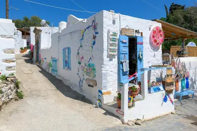 a white building with paintings on the side of it at White House 1871 in Lachania