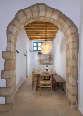 an archway in a dining room with a table at White House 1871 in Lachania