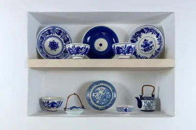 a shelf filled with blue and white plates and bowls at White House 1871 in Lachania