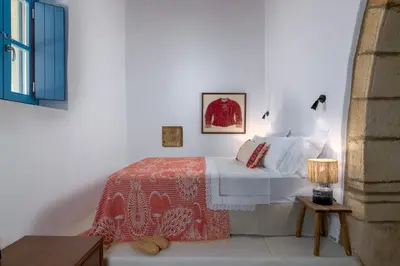 a white bedroom with a bed and a table at White House 1871 in Lachania