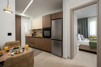 a kitchen and living room with a table and a room with a bed at Dia Luxury Apartments in Rhodes Town