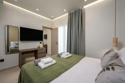 a bedroom with a large bed with two white towels at Dia Luxury Apartments in Rhodes Town