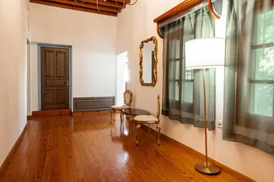 a living room with a table and chairs and a lamp at Harmonia - A Sanctuary in the Old Town of Rhodes in Rhodes Town