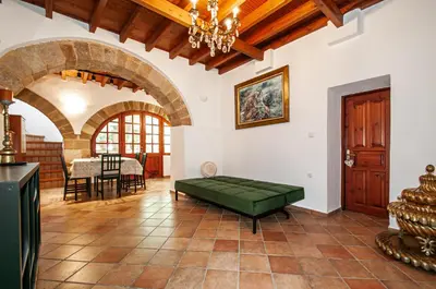 a living room with a green couch and a table at Harmonia - A Sanctuary in the Old Town of Rhodes in Rhodes Town