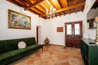 a living room with a green couch and a table at Harmonia - A Sanctuary in the Old Town of Rhodes in Rhodes Town