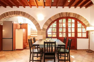 a kitchen with a table and chairs and a refrigerator at Harmonia - A Sanctuary in the Old Town of Rhodes in Rhodes Town