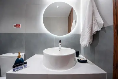 a bathroom with a white sink and a mirror at Dorothea Apartments #1 with sea view in Koskinou