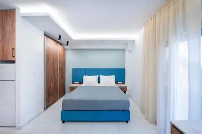 a bedroom with a blue bed and a window at Dorothea Apartments #2 with garden view in Koskinou